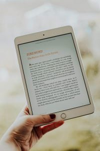 women hand holding ipad while reading a ebook